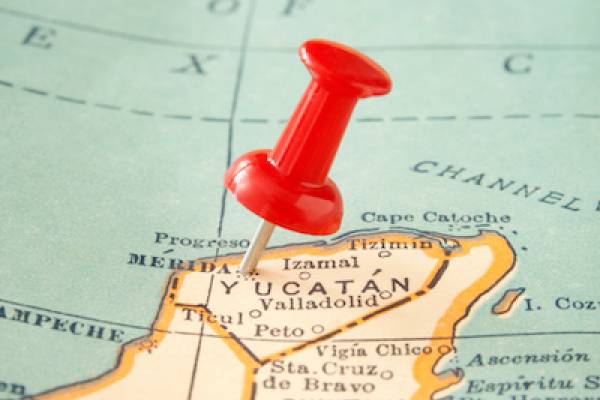 close up of a map with a red push-pin stuck in the Yucatan 