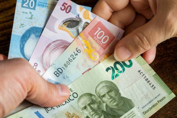 several different notes of Mexican currency changing hands