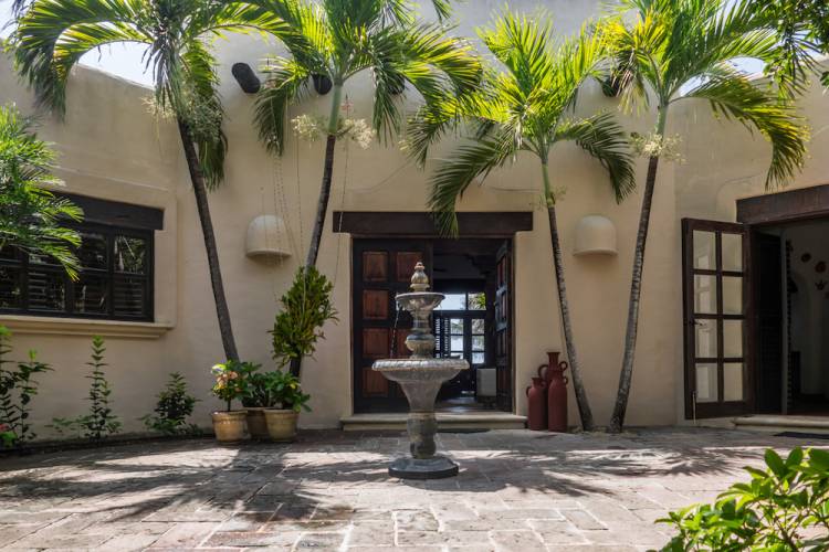 courtyard with palm trees and fountain at vacation rental in mexico
